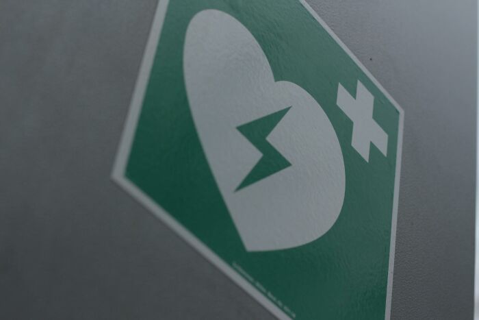 Close-up of a first aid defibrillator sign symbolizing hope and progress in America beyond negative headlines.
