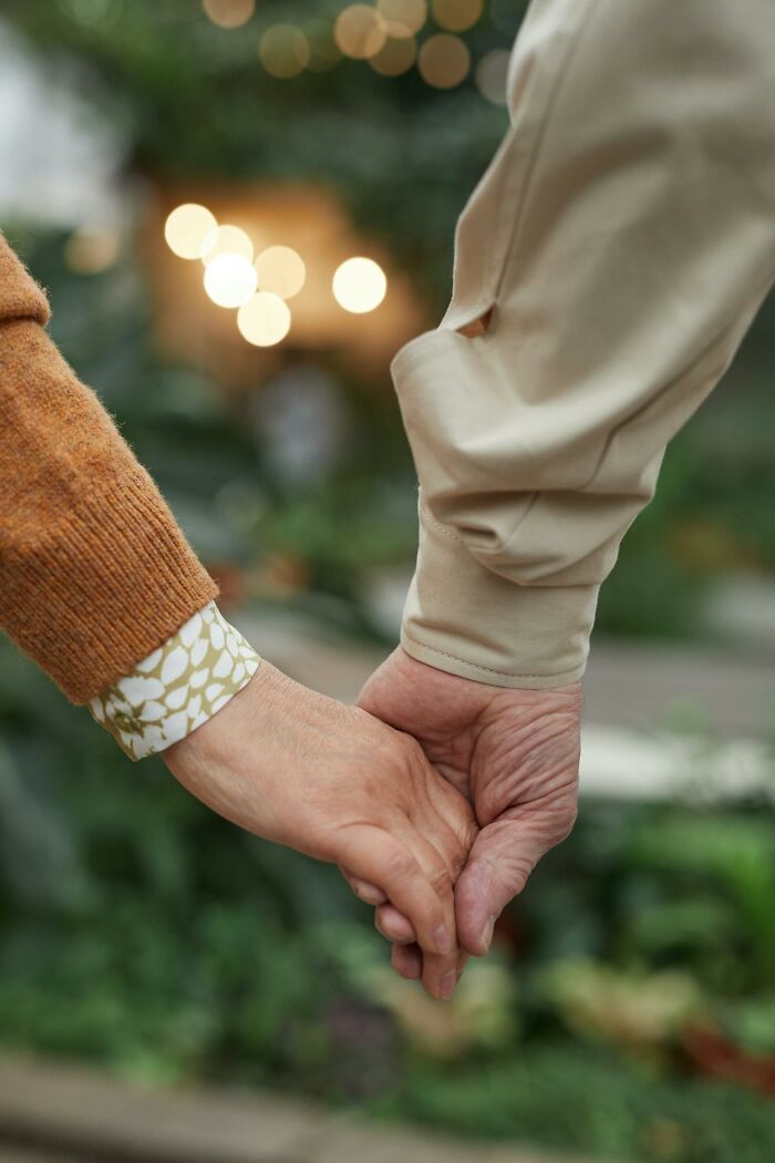 Two elderly people holding hands outdoors, symbolizing hope and unexplainable medical events.