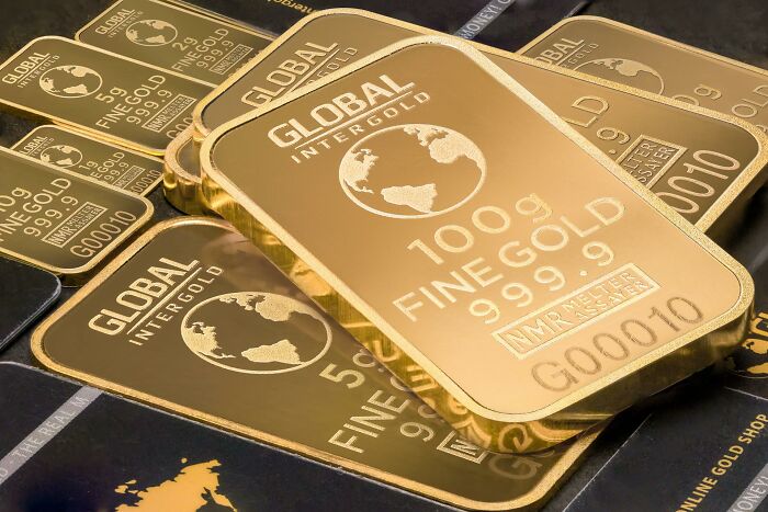Stacked gold bars with global map design, illustrating valuable lesser-known facts about countries.