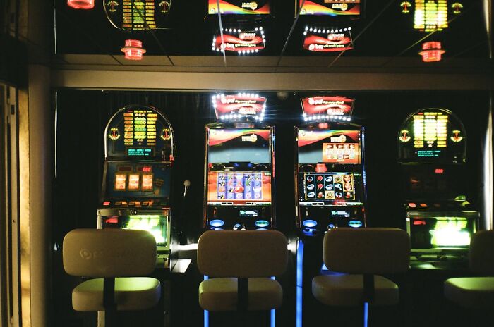 Slot machines lit up at night in a dark casino room, capturing the chaos and energy of the 3 AM night shift.