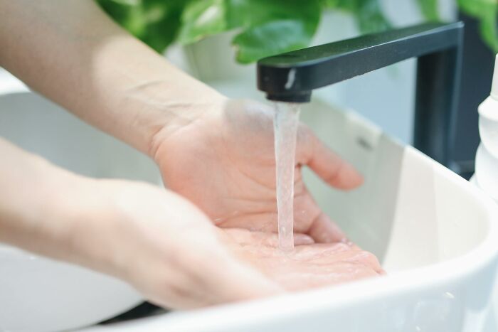 Hands washing under a modern faucet with running water, illustrating lesser-known facts about these countries.