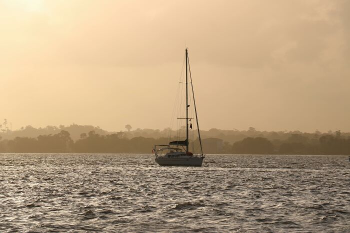 Sailboat floating on calm water at sunset, showcasing scenic views related to lesser-known facts about countries.