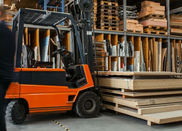 Forklift operating in an industrial warehouse, highlighting people behind boring industries and dramatic behind-scenes work.