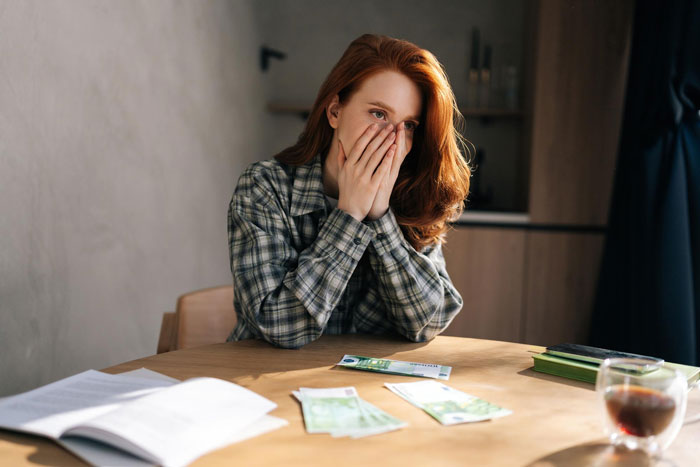 Woman with kids sitting at a table, looking worried after realizing she was being used by a new friend. Woman with kids sitting at a table, looking worried after realizing she was being used by a new friend.