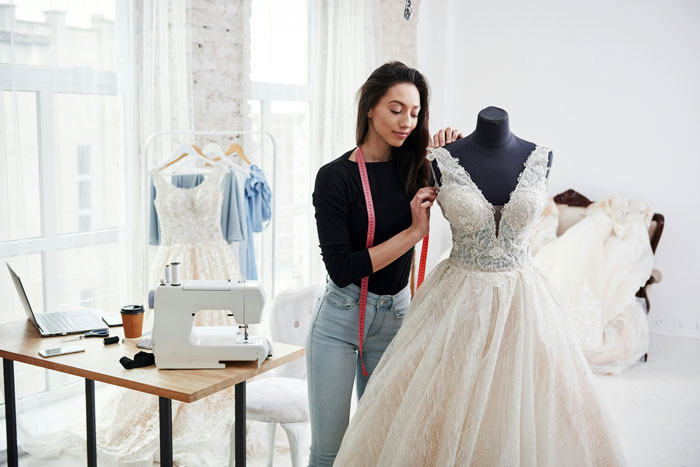 Woman working on daughter's wedding dress, delicately adjusting lace on a mannequin in a bright sewing studio. Woman working on daughter's wedding dress, delicately adjusting lace on a mannequin in a bright sewing studio.