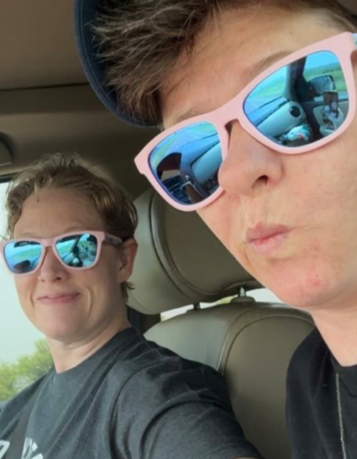 Two women wearing pink sunglasses sitting inside a car, related to Renee Good’s wife breaking silence on fatal ICE incident. Two women wearing pink sunglasses sitting inside a car, related to Renee Good’s wife breaking silence on fatal ICE incident.