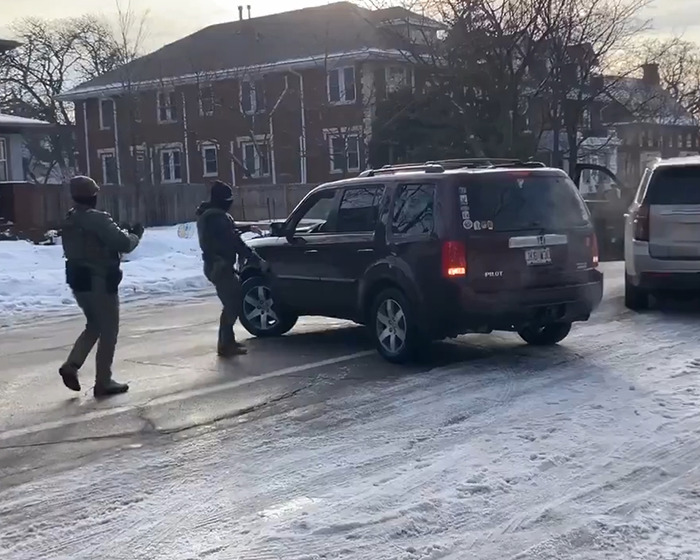 Two law enforcement officers approach a black SUV on a snowy street related to ICE video and fatal shooting context. Two law enforcement officers approach a black SUV on a snowy street related to ICE video and fatal shooting context.