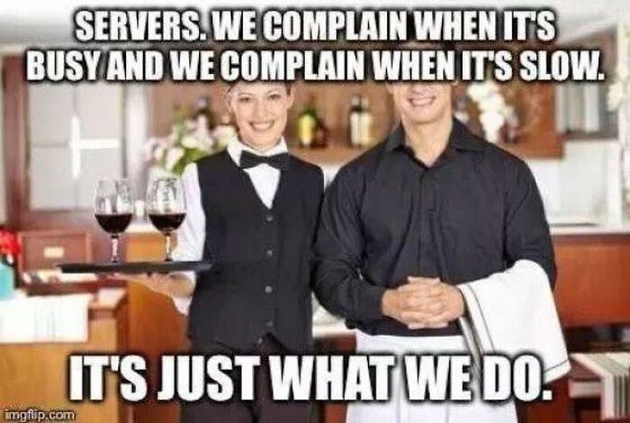 Two restaurant workers in uniform smiling in a busy restaurant illustrating relatable restaurant worker memes.