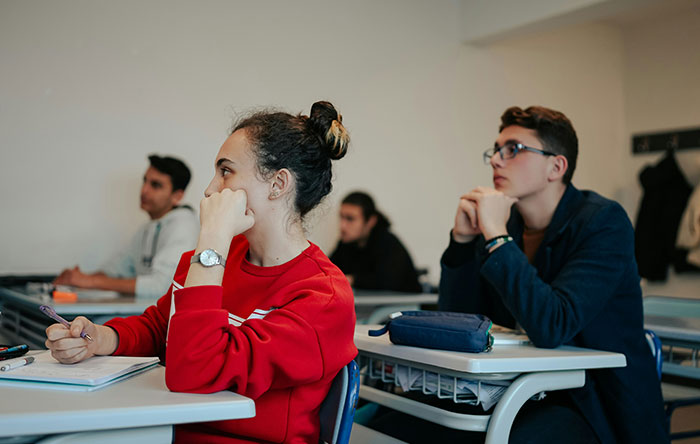 Students in a classroom attentively listening, illustrating moments of focus and determination for glorious revenge.