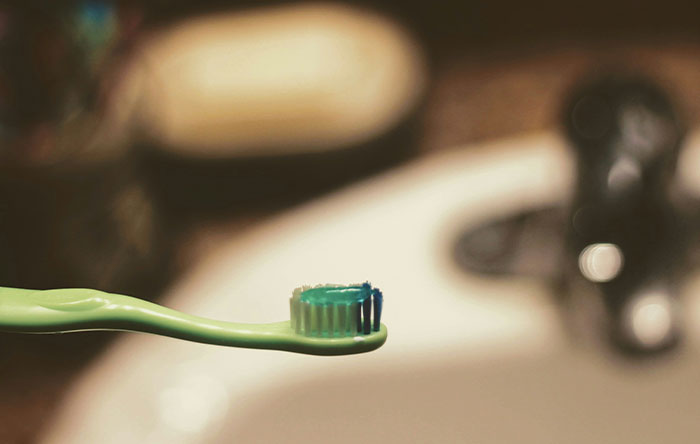 Toothbrush with toothpaste in a bathroom setting, symbolizing self-care and the last laugh revenge theme.