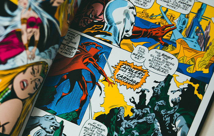 Close-up of colorful comic book pages showing a dramatic revenge scene with superheroes and speech bubbles.