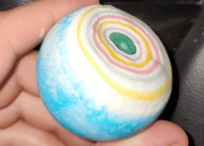 Close call experience symbolized by a colorful round candy held gently between fingers, representing terrifying close calls.