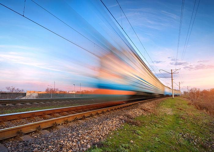 High-speed train rushing along tracks at sunset, illustrating terrifying close calls and near accident moments.