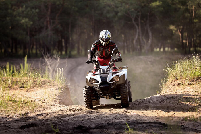 Person riding an ATV through a forest trail, symbolizing high school bully encounters and karma moments in adulthood.