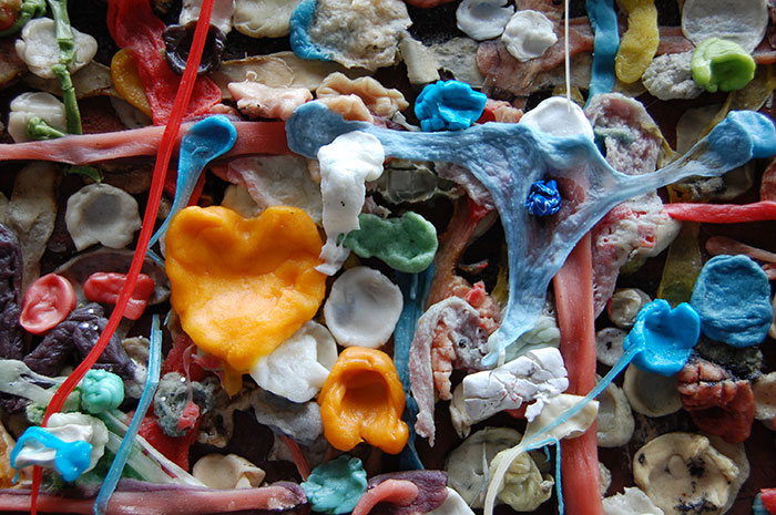 Close-up of colorful chewing gum stuck on a wall, resembling weird camera footage seen by security guards.