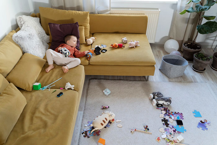 Toddler asleep on a yellow couch surrounded by toys, highlighting concerns of mom's neglect and CPS involvement. Toddler asleep on a yellow couch surrounded by toys, highlighting concerns of mom's neglect and CPS involvement.