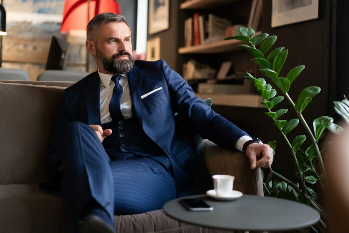 Man in a blue suit looking thoughtful indoors, reflecting on moments they no longer wanted to work at their job.