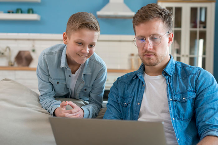 Young man and stepson managing family money and college planning together using a laptop at home. Young man and stepson managing family money and college planning together using a laptop at home.