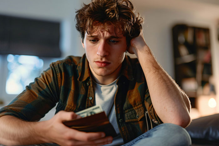 Teen looking stressed holding wallet and money, reflecting on first car debt trap and sending $40k loan back to mom. Teen looking stressed holding wallet and money, reflecting on first car debt trap and sending $40k loan back to mom.