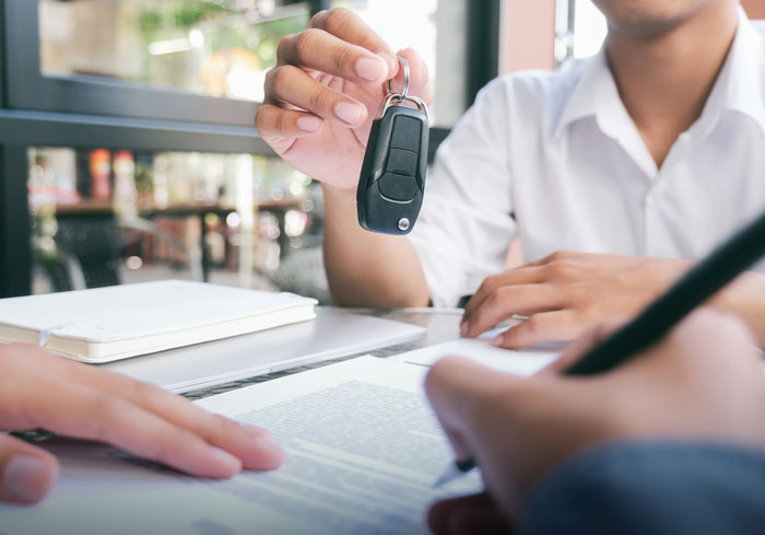 Teen holding first car key while signing loan documents, illustrating a debt trap set by mom and a $40k repayment. Teen holding first car key while signing loan documents, illustrating a debt trap set by mom and a $40k repayment.
