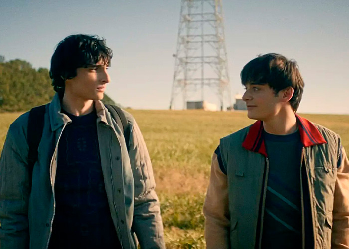 Stranger Things star Noah Schnapp and co-actor walking outdoors with a tower in the background during a scene. Stranger Things star Noah Schnapp and co-actor walking outdoors with a tower in the background during a scene.
