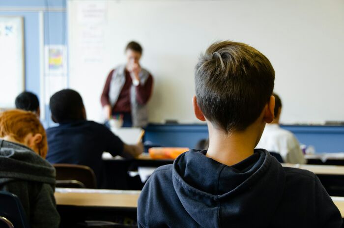 Students sitting in a classroom while a teacher talks, illustrating weirdest teacher behavior witnessed in class.