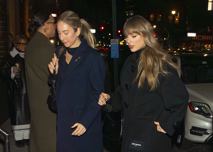 Taylor Swift leaving a friend's wedding in a dark coat, outfit scrutinized by fans for trying to upstage the bride at night. Taylor Swift leaving a friend's wedding in a dark coat, outfit scrutinized by fans for trying to upstage the bride at night.