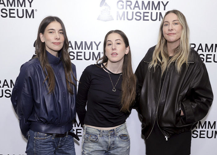 Three women posing at the Grammy Museum event, with fans scrutinizing Taylor Swift's wedding look for upstaging concerns. Three women posing at the Grammy Museum event, with fans scrutinizing Taylor Swift's wedding look for upstaging concerns.