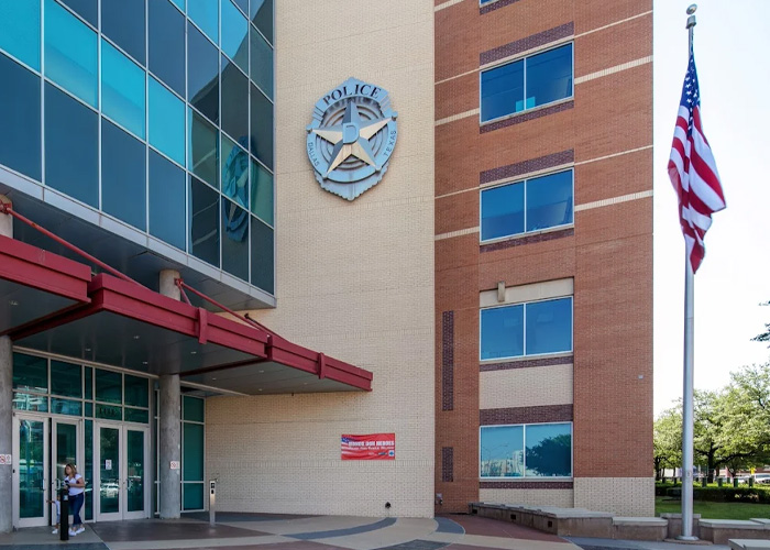 Police station entrance and American flag, conveying Closure in a Dallas missing persons case. Police station entrance and American flag, conveying Closure in a Dallas missing persons case.