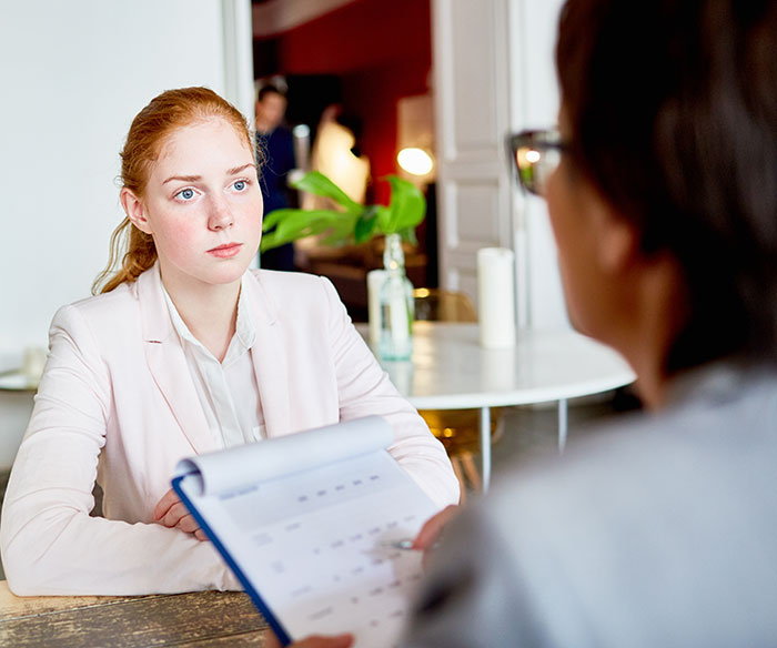 Young job candidate attentively listening during an interview with recruiters assessing qualifications.
