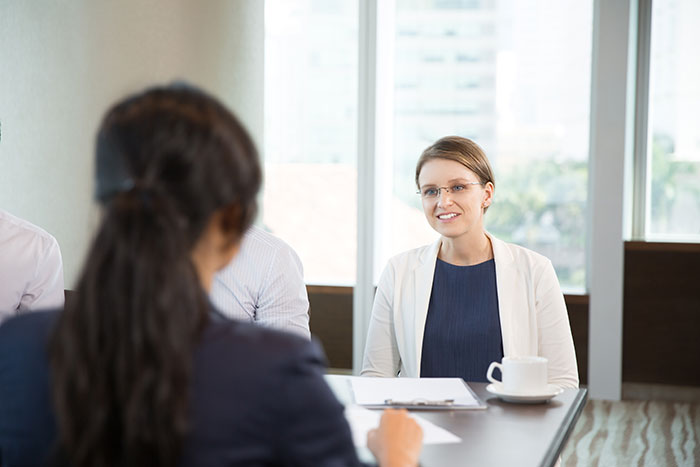Recruiter interviewing job candidates in a modern office, evaluating traits that impact chances of getting the job.