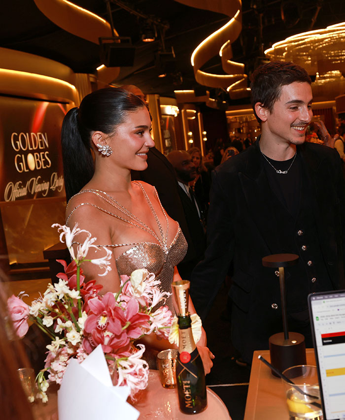 Timoth&eacute;e Chalamet with a woman at a Golden Globes event, highlighting their tension after fight exposure.