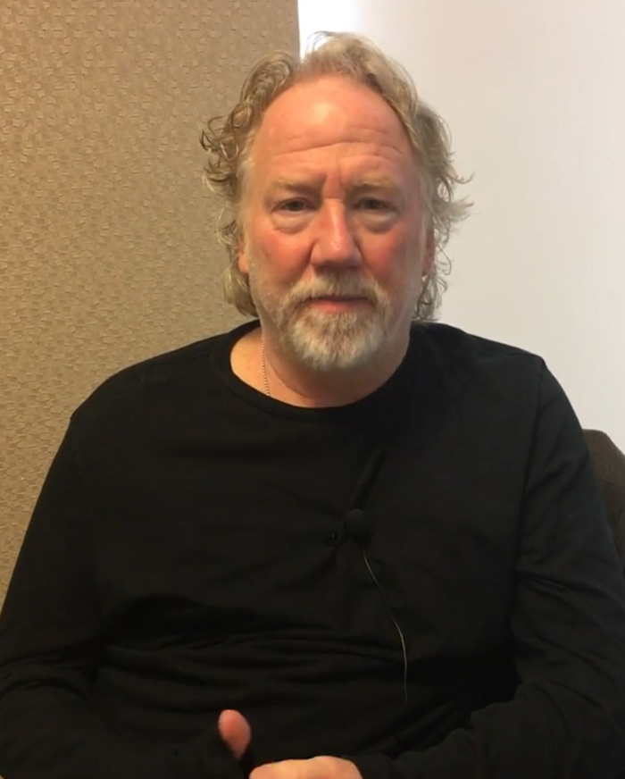 Middle-aged man with gray hair and beard wearing black shirt, sitting indoors, related to Melissa Gilbert lengthy letter to judge.
