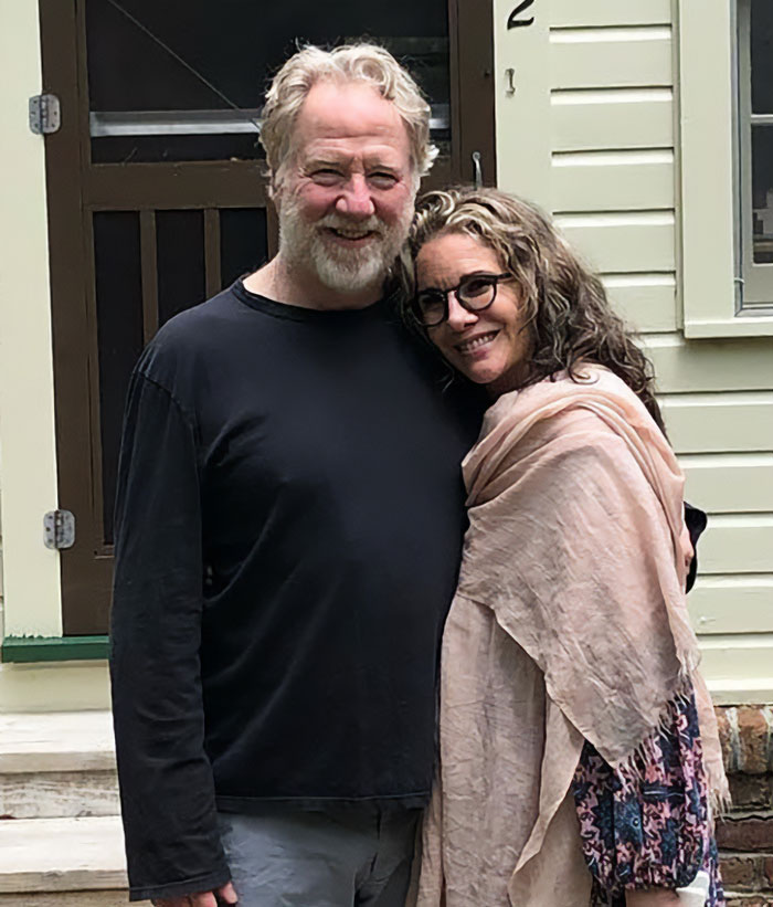 Timothy Busfield smiling with a woman outside a house, related to audio revealing accusers denying claims.