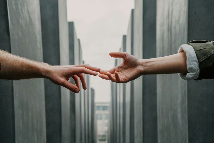 Two hands reaching out to each other, symbolizing connection and experiences of former cult members.