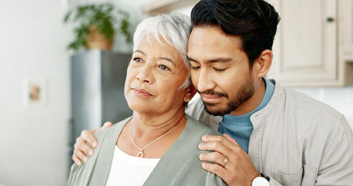 Young man gently comforting overbearing mother-in-law as daughter-in-law puts her foot down on plans made without her. Young man gently comforting overbearing mother-in-law as daughter-in-law puts her foot down on plans made without her.