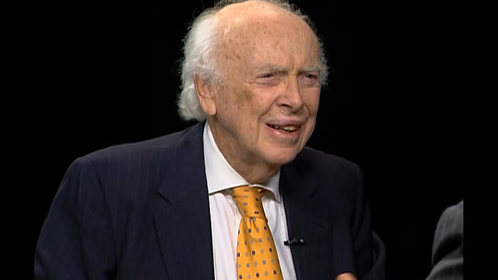 Elderly man in a suit and yellow tie sharing a story about meeting idols and regretting it deeply.