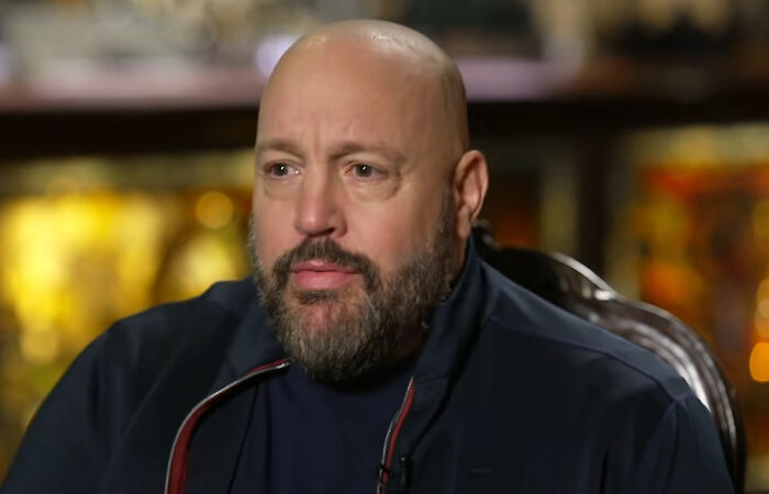 A bald man with a beard sitting indoors, reflecting on moments people met their idols in real life and regretted it.