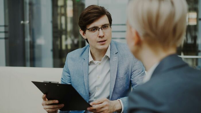 Young professional in blue blazer holding clipboard, discussing career moments when people realized quitting their current job was needed