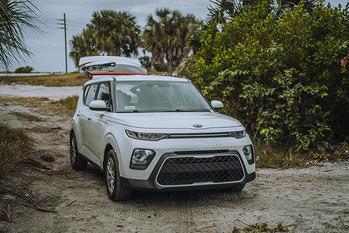 White Kia Soul parked on a sandy path near greenery, illustrating a moment of attraction ending due to a weird ick.