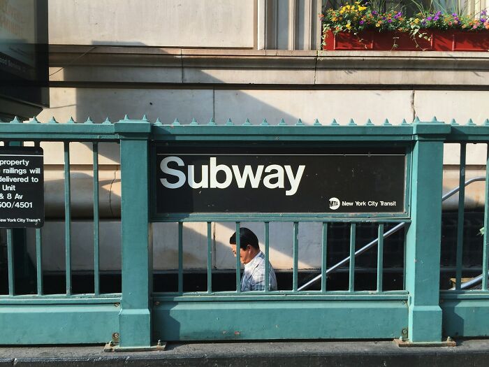 Man walking past a New York City subway entrance, illustrating weird and shocking things people did in public with zero shame.