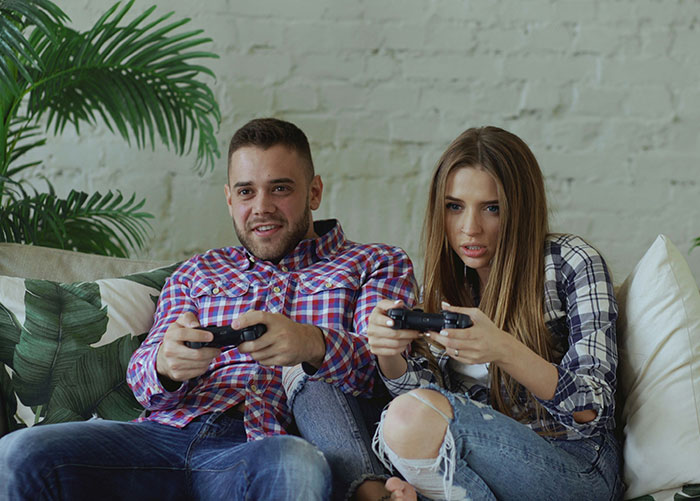 Man playing video games with intense focus, enjoying secret Star Wars figures hobby despite wife's ban.