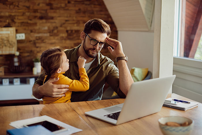 Dad struggling to keep toddler from mom who is studying, showing how a 2-year-old can outsmart a parent at home. Dad struggling to keep toddler from mom who is studying, showing how a 2-year-old can outsmart a parent at home.