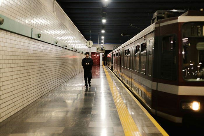 Man walking alone on subway platform at night, a scene some people witnessed and found weird to explain.