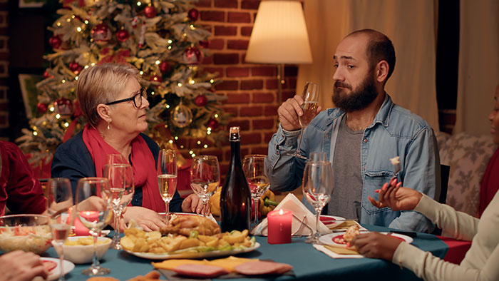 Woman appalled by chauvinist brother and gaslighting mom, family drama at holiday dinner table. Woman appalled by chauvinist brother and gaslighting mom, family drama at holiday dinner table.