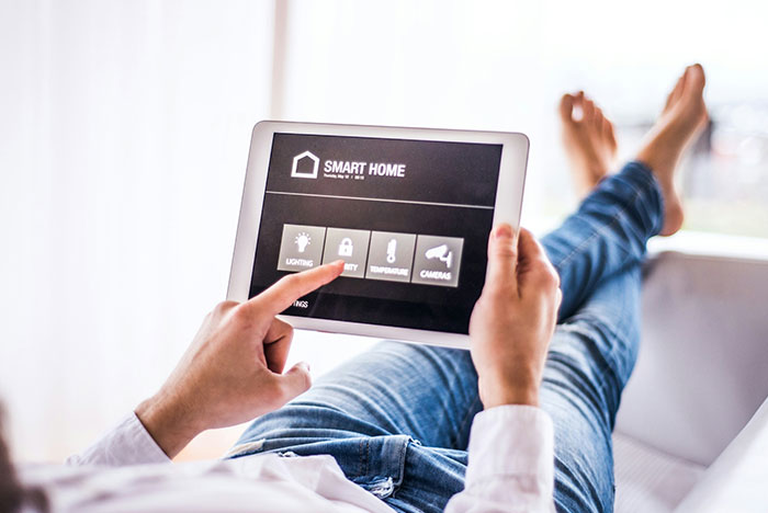 Man using smart home tablet controlling lighting and security, noticing strange things happening in apartment. Man using smart home tablet controlling lighting and security, noticing strange things happening in apartment.