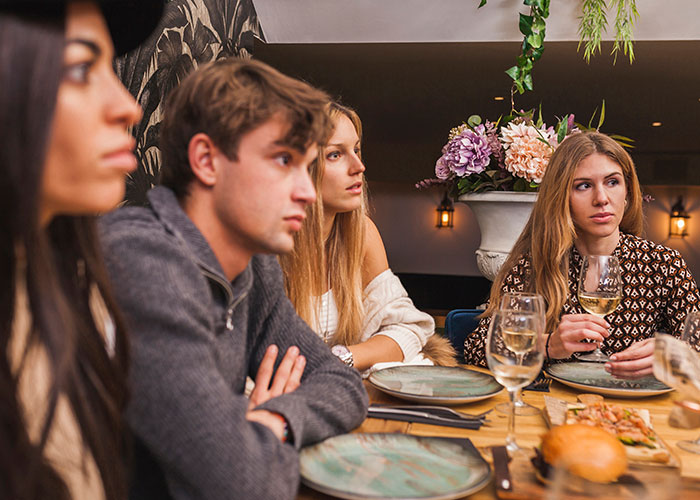 Young woman refusing to risk her new career while her friends show their true colors at a dinner gathering.