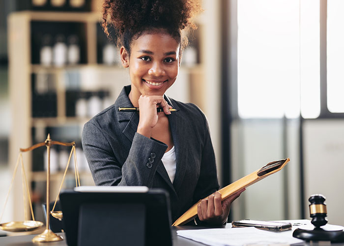 Young woman in professional attire holding a folder, confidently protecting her new career from free advice requests.