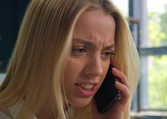 Woman talking on phone with upset expression, illustrating conflict over engagement party and friendship issues.