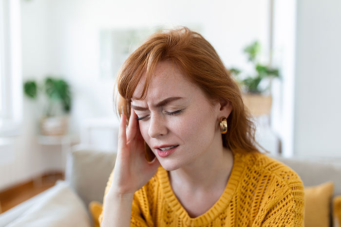 Daycare worker feeling stressed and confused indoors, reacting to a possible passive-aggressive coworker gift situation. Daycare worker feeling stressed and confused indoors, reacting to a possible passive-aggressive coworker gift situation.